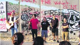 Els músics de la brigada davant del mur que encercla Cisjordània