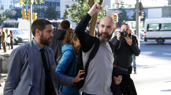 El regidor de la CUP Josep Garganté aixeca el puny davant de la Guàrdia Urbana mentre marxa de la Ciutat de la Justícia després de quedar absolt.